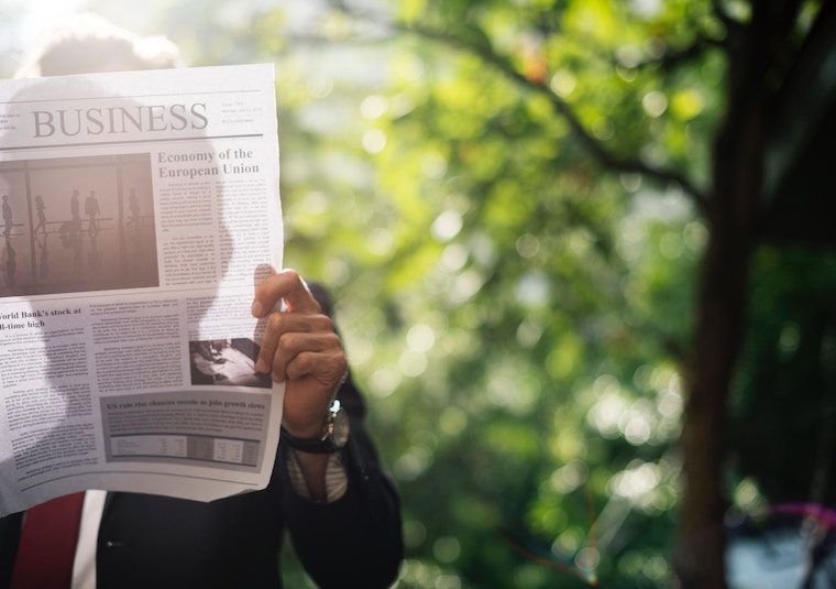 man holding newspaper green, responsible investment