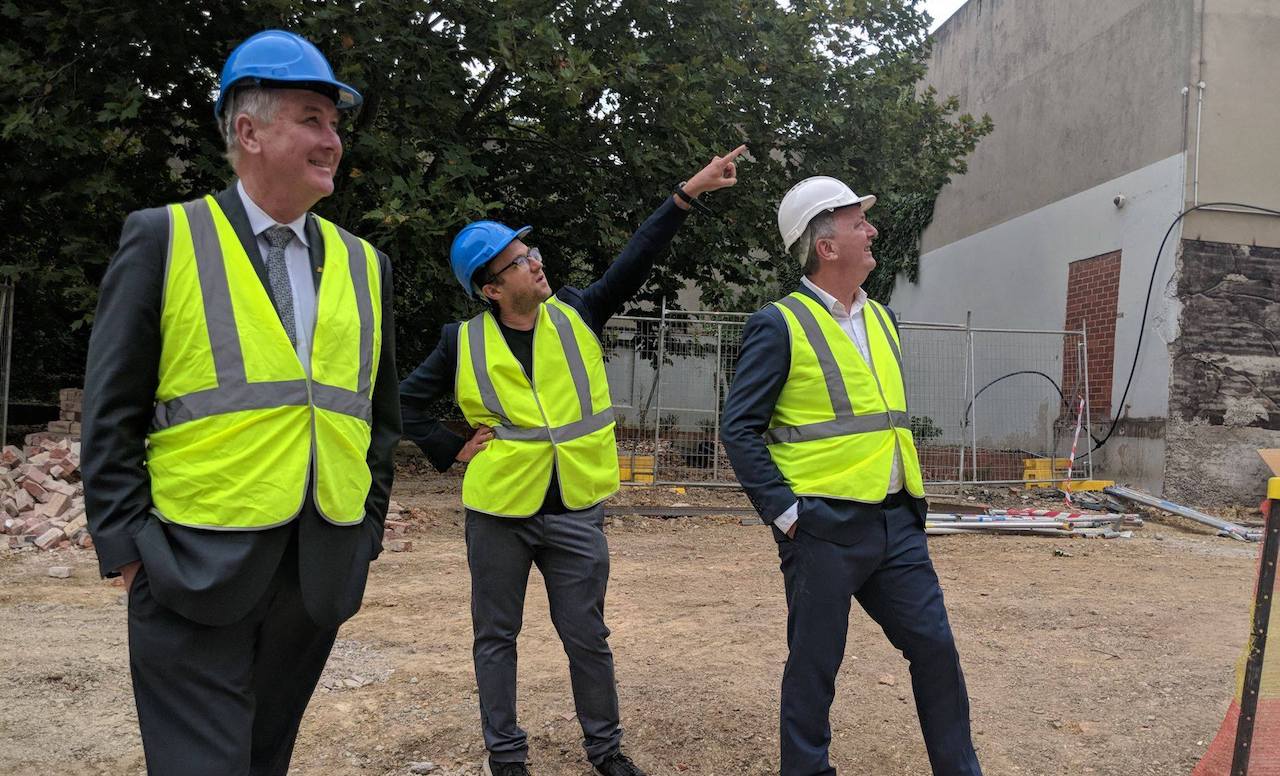 Richard Wynne at construction site with two men