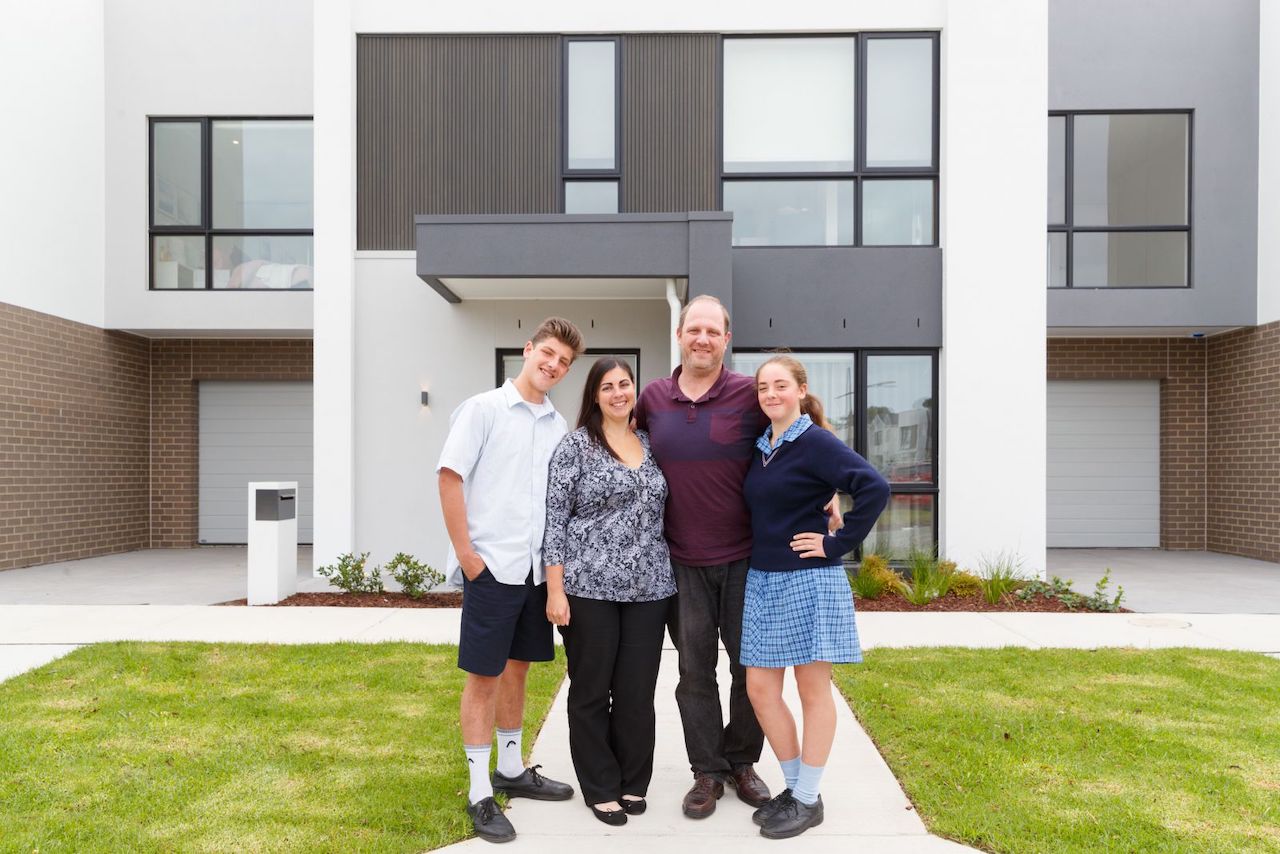 family in front of house