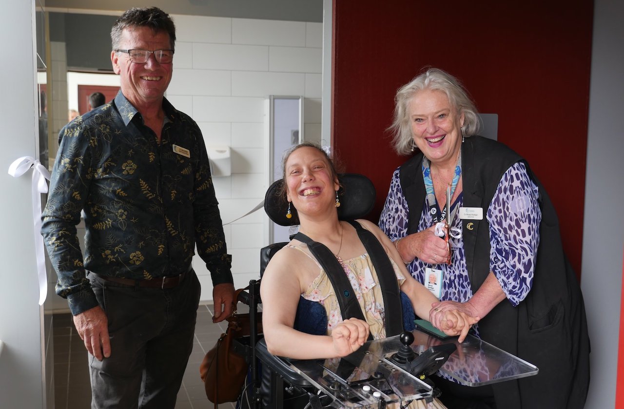 woman in wheelchair smiling with man and woman