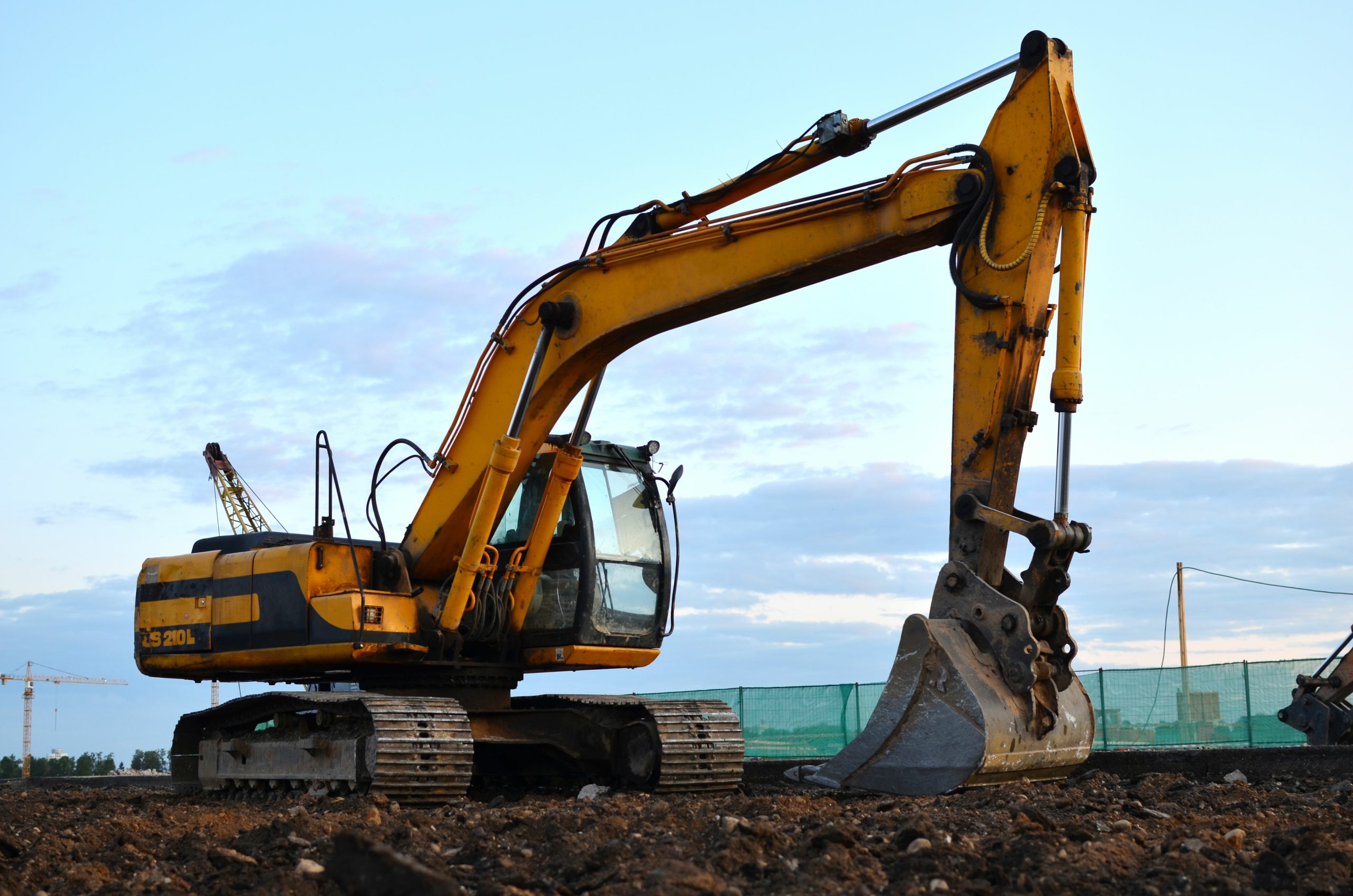 excavator on a construction site. Road repair, asphalt replacement. Loading of stone and rubble for its processing at a concrete factory into cement for construction work.