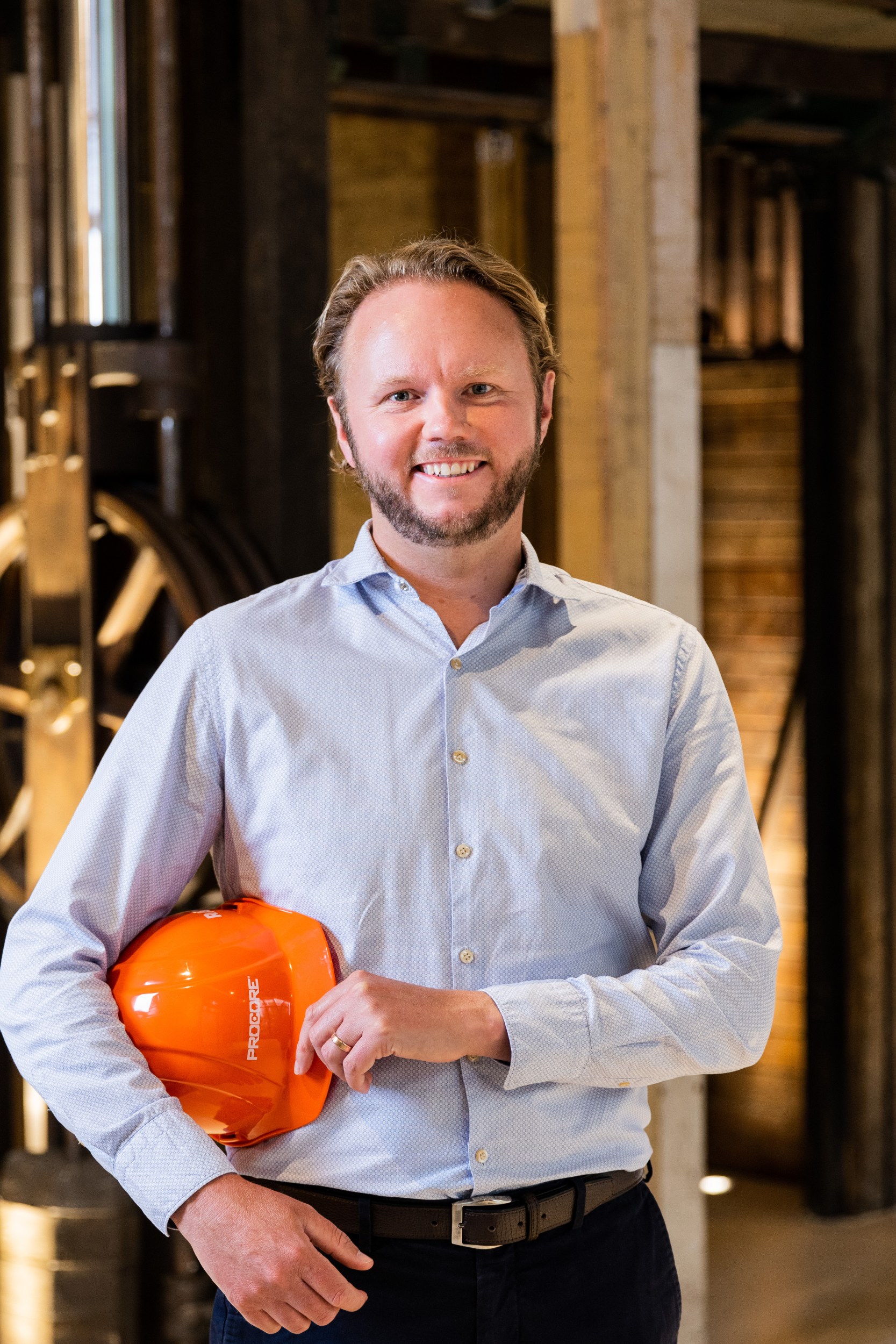 Smiling man holding construction hard hat