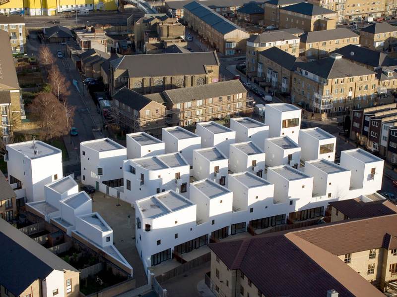 white housing block, multiple buildings surrounded by dark brown apartment buildings