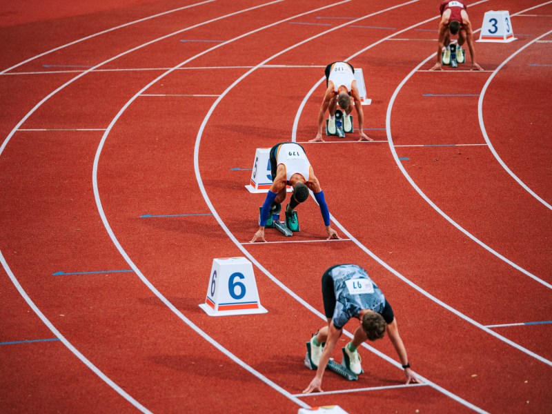 athletes on staggered starting block for running race