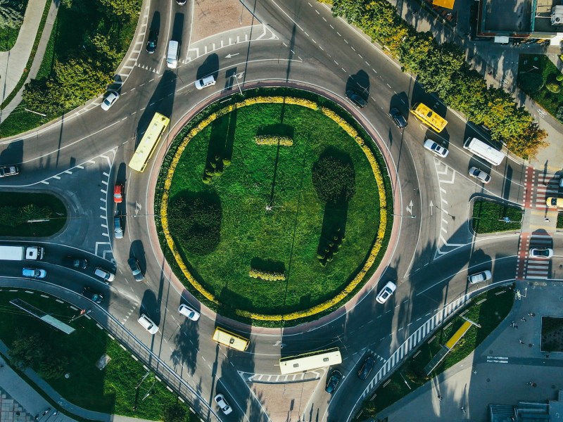Top view of traffic and people, cars and buses at rush hour at circular junction. High quality photo