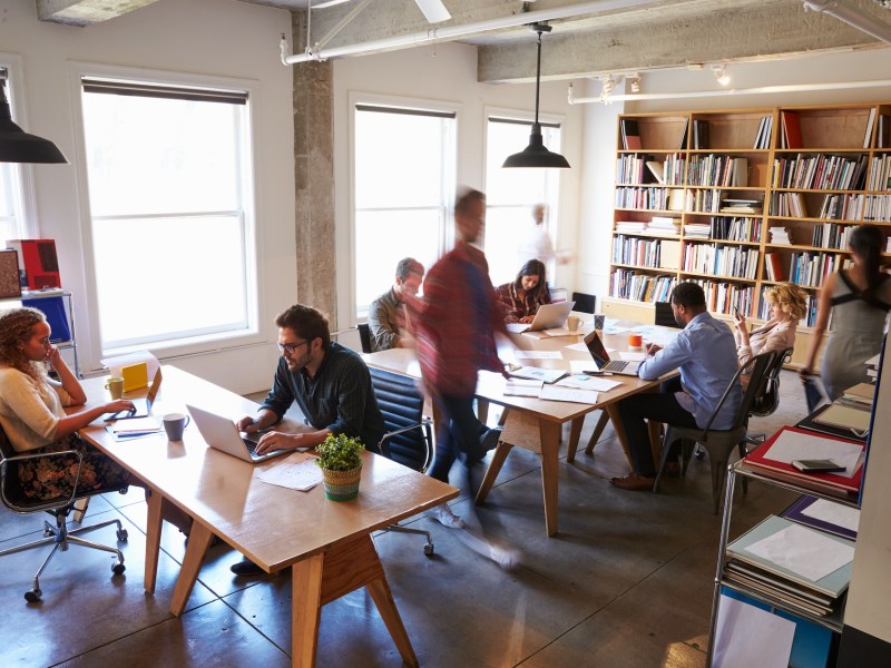 Overhead View Of Businesspeople Working At Desks In Office